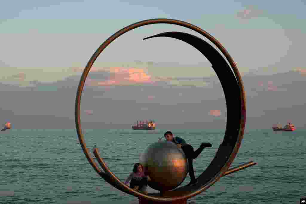 Children play on an art sculpture by the sea in southern port city of Limassol, Cyprus.