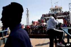 A ferry carrying people who fled Gambia arrives at the port in Banjul, Gambia, Jan. 22, 2017, one day after Gambia's defeated leader Yahya Jammeh left the country.