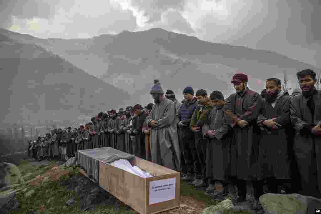 Relatives and neighbors pray by the body of Rameez Ahmad, a policeman who was killed in Monday&#39;s gun attack, during his funeral in Yachama, northeast of Srinagar, Indian-controlled Kashmir.