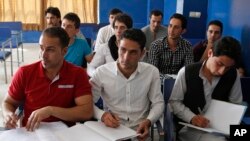 FILE - Afghan students take notes in a business administration class at Kardan University in Kabul, Afghanistan, Sept. 10, 2013. By targeting the educated militants hope to increase the number of uneducated youth – a prime demographic in Afghanistan.