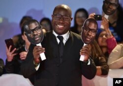 Director Steve McQueen poses with paper cutouts of his face as he attends the premiere for "Widows" on day 3 of the Toronto International Film Festival at Roy Thomson Hall, Sept. 8, 2018, in Toronto.