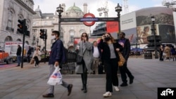 영국의 신종 코로나바이러스 감염 확진자가 다시 늘고 있는 가운데, 마스크를 착용한 시민들이 19일 런던 시내 지하철역 앞에서 걷고 있다. 