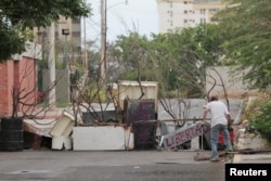 An opposition supporter blocks a road during a strike called to protest against Venezuelan President Nicolas Maduro's government in Maracaibo, Venezuela, July 20, 2017.