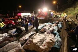 Bodies are covered at the scene of a crash where a bus collided with a car on a highway in Taipei, Taiwan, Feb. 13, 2017.
