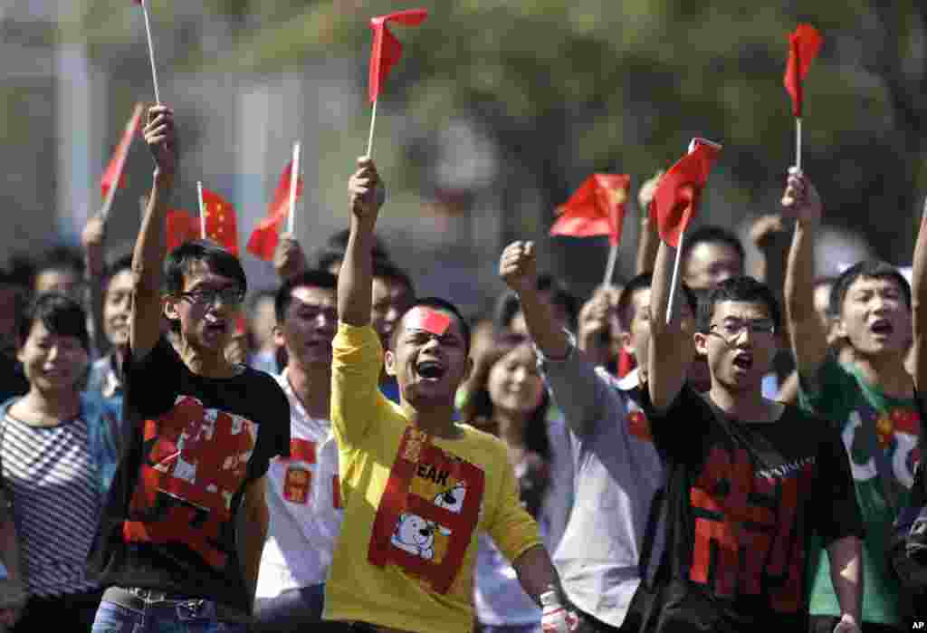 Chinese protesters with the words "Boycott Japanese goods" on their shirts march towards the Japanese Embassy in Beijing, China, September 16, 2012. 