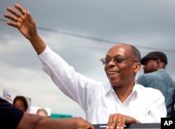 Haiti's former President Jean-Bertrand Aristide waves to supporters as he campaigns with presidential candidate Maryse Narcisse of the Fanmi Lavalas political party, in Petion-Ville, Haiti, Aug. 29, 2016.
