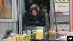 FILE - An elderly Ukrainian woman sells home made products in downtown Kyiv, Ukraine, Feb. 3, 2016. 