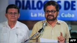 Head of FARC-EP leftist guerrillas delegation, Ivan Marquez (R) reads a statement during the peace talks with the Colombian government at Convention Palace in Havana, Nov. 9, 2015.