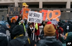 People gather to show support and protest former campaign adviser for President Donald Trump, Roger Stone, after he departed federal court in Washington, Tuesday, Jan. 29, 2019.