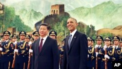 President Barack Obama, right, smiles after a group of children waved flags and flowers to cheer him during a welcome ceremony with Chinese President Xi Jinping at the Great Hall of the People in Beijing, China Wednesday, Nov. 12, 2014.