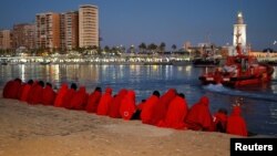 Migrants, part of a group intercepted aboard a dinghy off the coast in the Mediterranean Sea, rest after arriving on a rescue boat at the Port of Malaga, Spain, Dec. 7, 2017. 