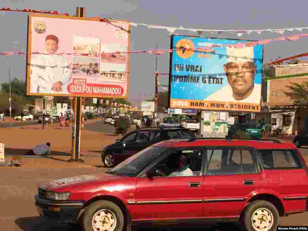 Les affiches des deux candidats à la présidentielle du dimanche, le président sortant Mahamadou Issoufou, et d&rsquo;un de ses adversaires, Hama Amadou, trônent sur un carrefour de Niamey, Niger, 17 février 2016. (VOA/Nicolas Pinault).