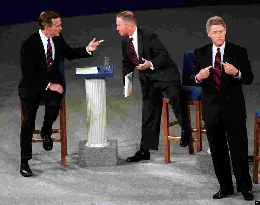 This October 15, 1992 photo shows then President George H. W. Bush, talking with independent candidate Ross Perot as Democratic candidate Bill Clinton stands aside at the end of their second presidential debate in Richmond, Virginia. 