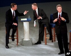 FILE - Then-President George H. W. Bush, talking with independent candidate Ross Perot as Democratic candidate Bill Clinton stands aside at the end of their second presidential debate in Richmond, Virginia, October 15, 1992.