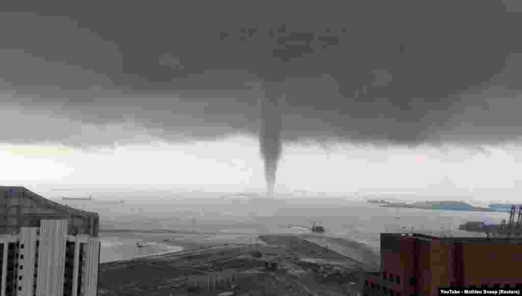 Boats sail near a swirling waterspout in Singapore, May 11, 2019, in this picture obtained from social media.