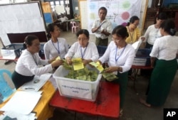 Officials of Union Election Commission prepare to count ballots as the time-period for casting votes ends at a polling station in Yangon, Myanmar, Saturday, April 1, 2017.