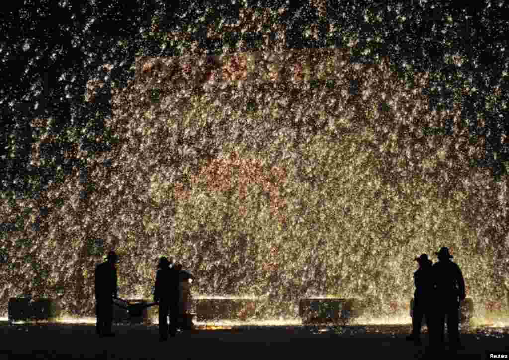 Pengisi acara menyemprot lelehan besi ke arah dinding untuk menyambut Festival Lentera di kota Nuanquan, kotamadya Yuxian, provinsi Hebei, China, 1 Maret 2015.