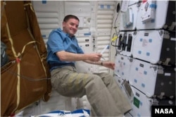 FILE - Mission specialist Rex Walheim performs checks of the Cell Culture Module aboard the U.S. space shuttle Atlantis in 2011. (NASA)