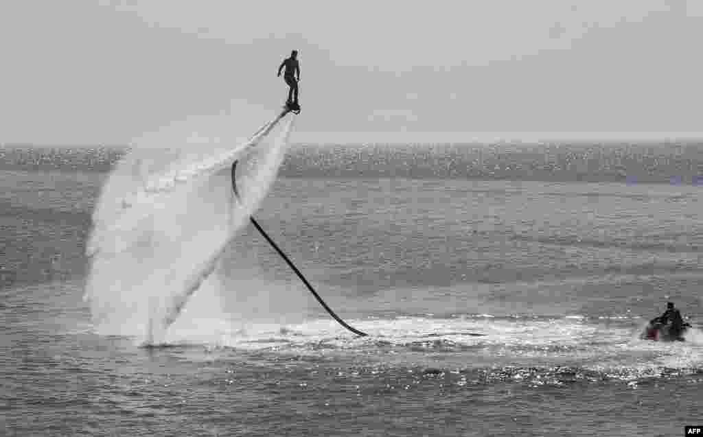 A Libyan rides an electric surfboard in the Mediterranean sea in the capital Tripoli, July 5, 2019.