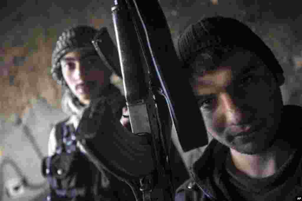 Thursday, Dec. 13, 2012 photo shows Syrian rebels pose for a photo in Aleppo, Syria. (AP Photo/Narciso Contreras)