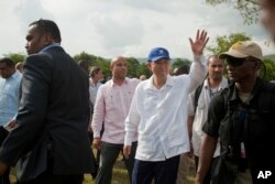 FILE - U.N. Secretary-General Ban Ki-moon, center wearing blue cap, greets residents during the launching of sanitation campaign in Hinche, Haiti, July 14, 2014.