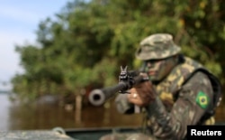 A Brazilian Army soldier patrols the border with Colombia during a training to show efforts to step up security along borders, in Vila Bittencourt, Amazon State, Brazil, Jan. 18, 2017.