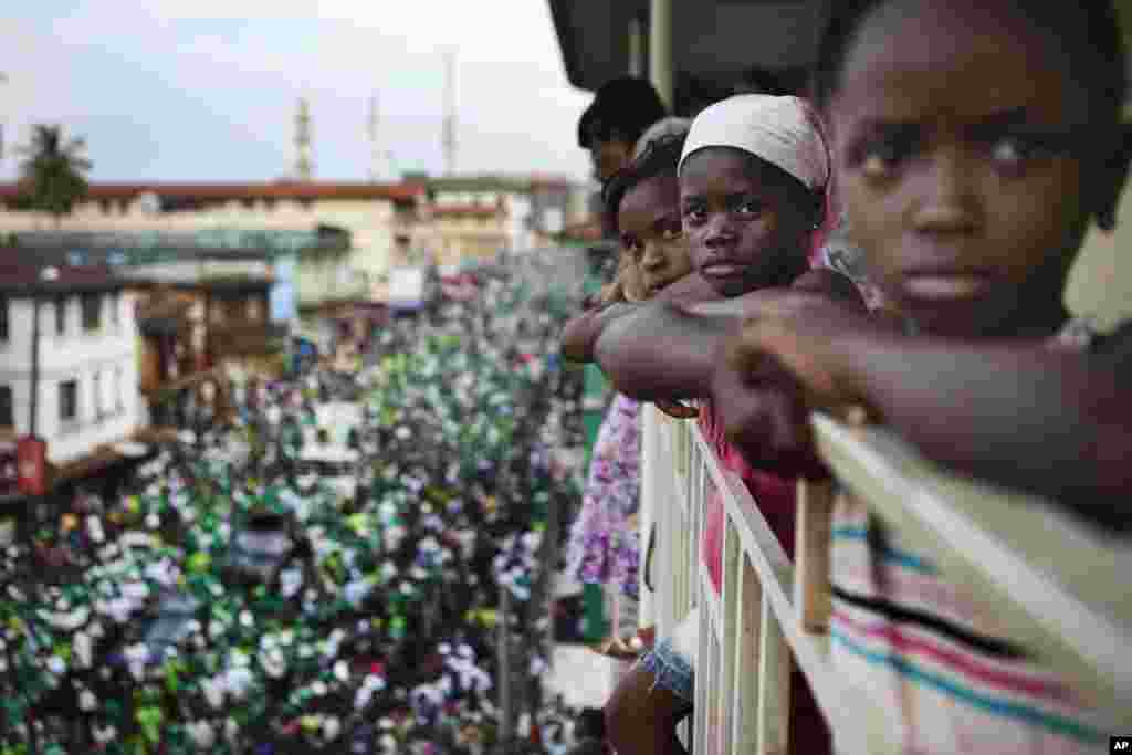 Girls watch a rally for Sierra Leone opposition presidential candidate Julius Maada Bio from their terrace in downtown Freetown, November 15, 2012.