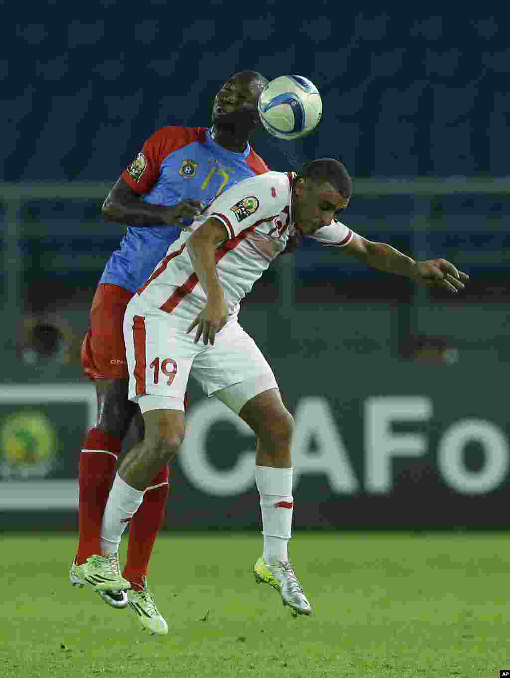Ahmed Akaichi de la Tunisie, avant-plan, battu dans les airs par la RD Congo Cedric Mongongu, le dos, au cours de leur match ddu groupe B de la CAN à Bata, en Guinée équatoriale, lundi 26 janvier 2015.