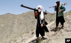FILE - Afghan Taliban fighters are seen carrying weapons in a May 27, 2016, photo.