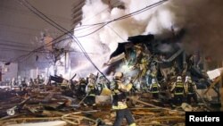 Petugas pemadam kebakaran berusaha memadamkan api pasca ledakan di restoran dua lantai di Sapporo, ibukota Pulau Hokkaido, Minggu (16/12). 