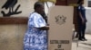 FILE - A woman fills in her ballots in presidential and parliamentary elections at a polling station in Accra, Ghana, Dec. 7, 2012. 