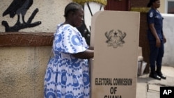 FILE - A woman fills in her ballots in presidential and parliamentary elections at a polling station in Accra, Ghana, Dec. 7, 2012. 