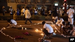 People light candles during a memorial ceremony for the victims of a recent hotel attack in which extremists killed at least 29 people in Ouagadougou, Burkina Faso, Jan. 23, 2016.