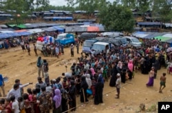 Newly arrived Rohingya refugees stand in a line to receive food rations in Kutupalong, Bangladesh, Sept. 30, 2017.