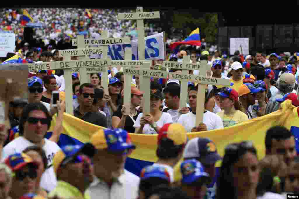 Una enorme bandera venezolana es llevada en medio de la manifestación.