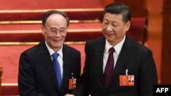 Ông Vương Kì Sơn (trái) và ông Tập Cận Bình bắt tay tại Đại hội Đại biểu Nhân dân Toàn quốc lần thứ 13 trong Đại lễ đường Nhân dân ở Bắc Kinh, ngày 17 tháng 3, 2018.