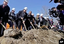 Taunton Mayor Thomas Hoye, far left, Tribal Chairman Cedric Cromwell, third from left, and others wield shovels during an official casino groundbreaking, April 5, 2016, in Taunton, Mass.