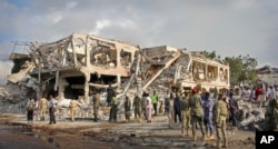 Somali security forces and others gather and search for bodies near destroyed buildings at the scene of Saturday's blast, in Mogadishu, Somalia, Oct. 15, 2017.