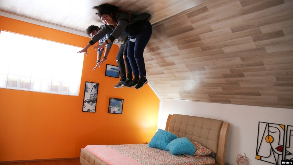 People pose for a photo inside the upside down house, in Guatavita, Colombia, January 23, 2022. (REUTERS/Luisa Gonzalez)