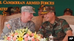 Lt. Gen. Hun Manet, right, son of Cambodian Prime Minister Hun Sen and deputy commander of the Royal Cambodian Army and Commander of the National Counter Terror Special Force, talks with an U.S. Army Pacific Representative Brg. Gen. John Goodale, left, as they preside over a U.S.-backed peacekeeping exercise dubbed "Angkor Sentinel 2014" at the Cambodian tank command headquarters in Kampong Speu province, 60 kilometers (37 miles) west of Phnom Penh, Cambodia, Monday, April 21, 2014. (AP Photo/Heng Sinith)