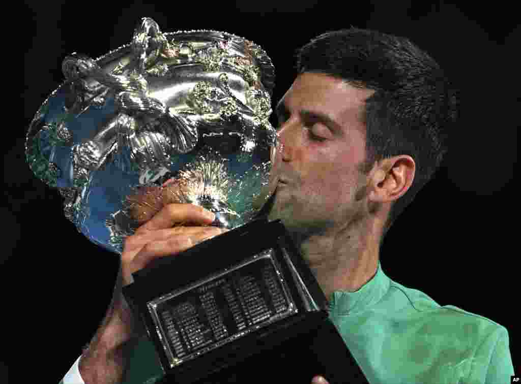 Serbia&#39;s Novak Djokovic kisses the Norman Brookes Challenge Cup after defeating Russia&#39;s Daniil Medvedev in the men&#39;s singles final at the Australian Open tennis championship in Melbourne, Australia.