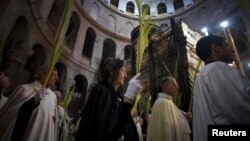 Christian clergy and worshipers hold palm fronds during a procession in the Church of the Holy Sepulcher in Jerusalem's Old City March 24, 2013.