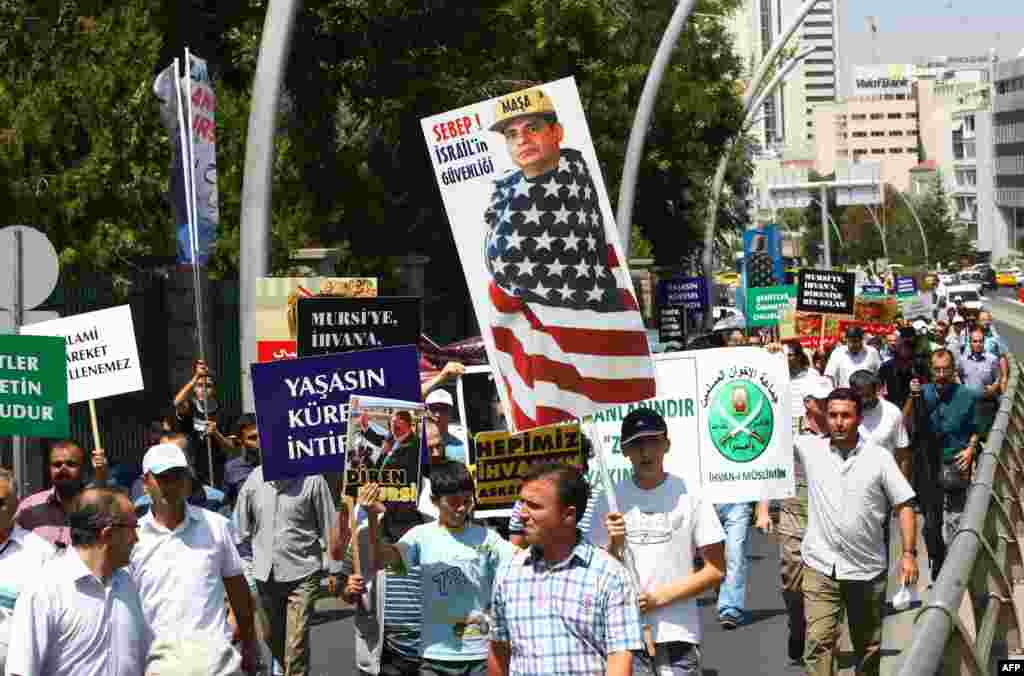 Turkish supporters of Egypt&#39;s ousted president Mohamed Morsi, holding a portrait mocking General Abdel Fattah al-Sisi, march during a demonstration condemning the deadly crackdown in Cairo outside the Egyptian embassy in Ankara, Aug. 14, 2013. 