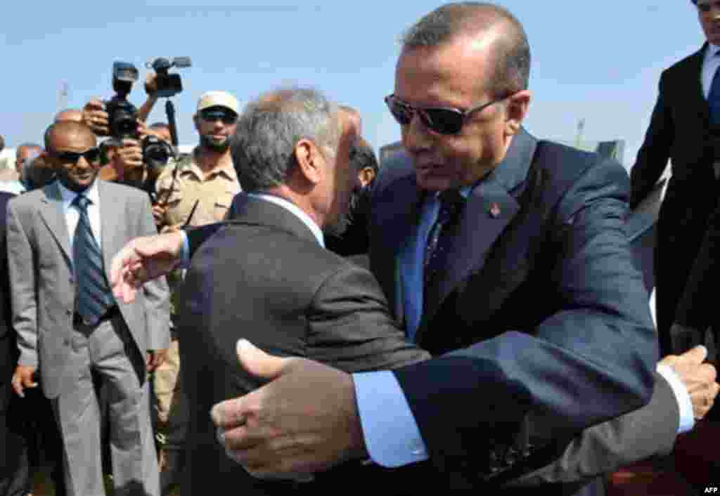 Libyan Transitional National Council chairman Mustafa Abdel Jalil, left, and Turkish Prime Minister Recep Tayyip Erdogan embrace each other upon Erdogan's arrival at Tripoli Airport, Libya, Friday, Sept. 16, 2011. Erdogan, intent on broadening Turkey's i