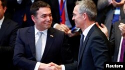 Macedonian Foreign Minister Nikola Dimitrov shakes hands with NATO Secretary-General Jens Stoltenberg during a signature ceremony of the accession protocol between the Republic of North Macedonia and NATO at the Alliance headquarters in Brussels, Feb. 6, 2019. 