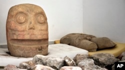 A skull-like stone carving and other parts representing the Flayed Lord are stored after being dug up from the Ndachjian–Tehuacan archaeological site in Tehuacan, Puebla state. This 2018 photo was provided by Mexico's National Institute of Anthropology. 