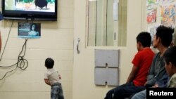 Anak-anak imigran ilegal, yang dipisahkan dari orang tua mereka, menonton film kartun sambil menunggu kedatangan ibu negara Melania Trump di fasilitas penahanan imigran di kota Tucson, Arizona (28/6). 