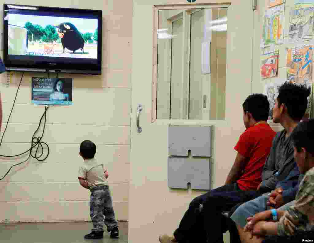 A detained immigrant child watches a cartoon while awaiting the arrival of U.S. first lady Melania Trump with other young detained immigrants at a U.S Customs and Border patrol immigration detainee processing facility in Tucson, Arizona.