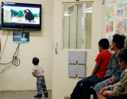 Seorang anak imigran yang ditahan menonton kartun sambil menunggu kedatangan ibu negara AS Melania Trump dengan imigran muda lainnya yang ditahan di fasilitas pemrosesan tahanan imigrasi patroli Bea Cukai dan Perbatasan AS di Tucson, Arizona, 28 Juni 2018. (Foto: Reuters)
