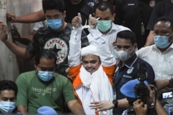 Pihak kepolisian menangkap Rizieq Shihab karena melanggar prokes COVID-19 dengan acara yang menarik ribuan pengikut, Jakarta, 13 Desember 2020. (Foto: dok)